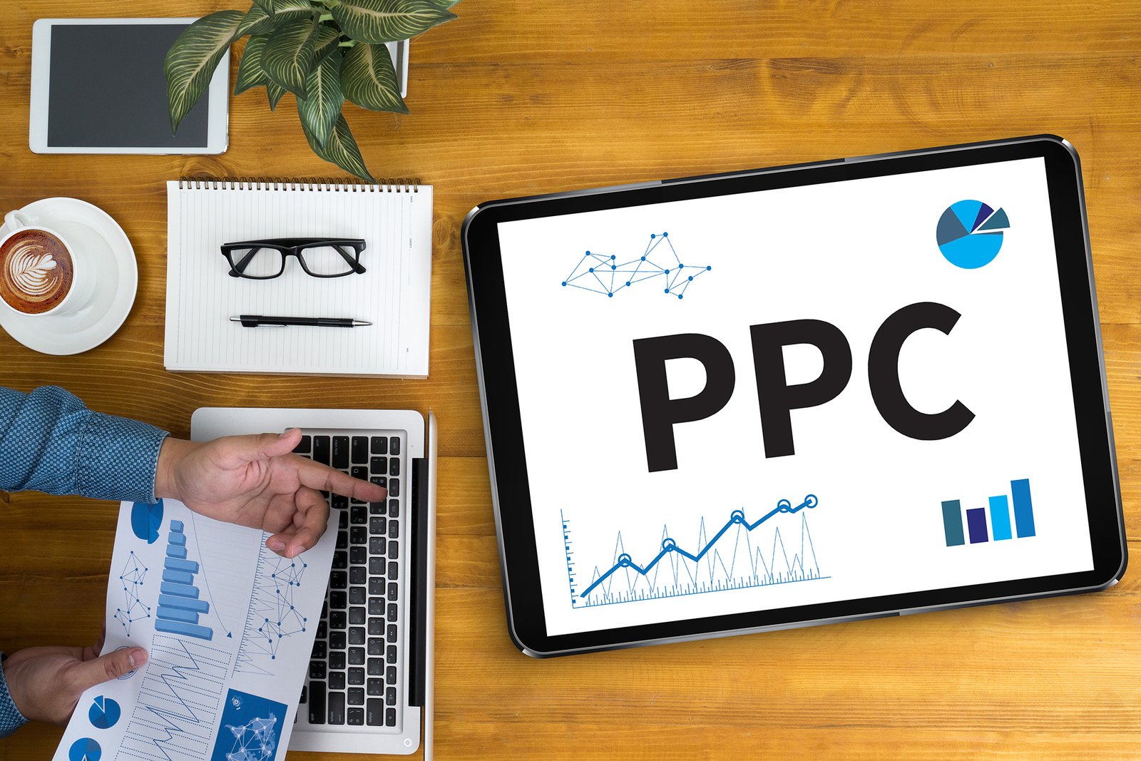 PPC - Pay Per Click concept Businessman working at office desk and using computer and objects, coffee, top view,